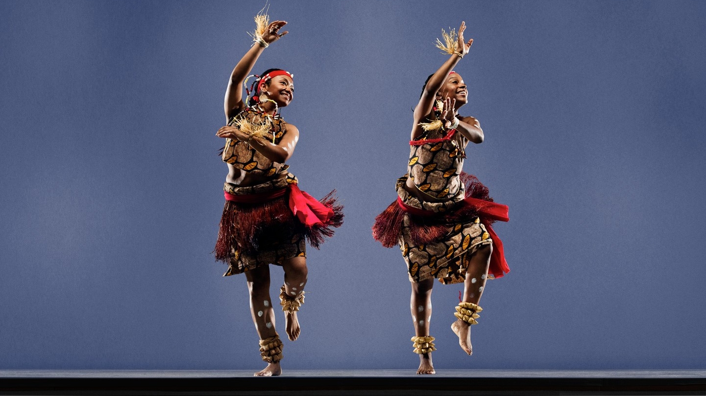 Two traditional Congolese dancers perform on stage.
