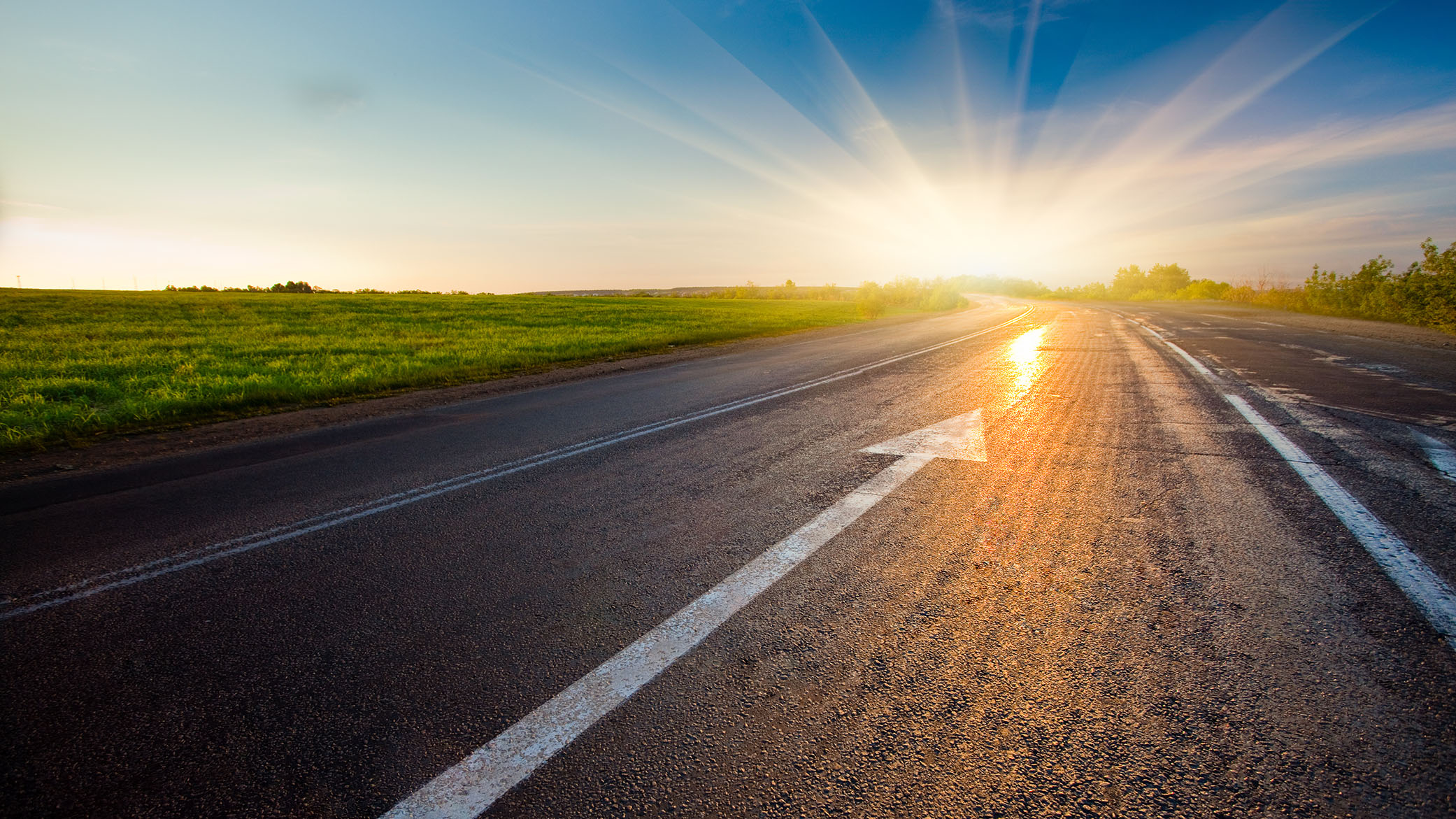 black asphalt road with arrow to sunset